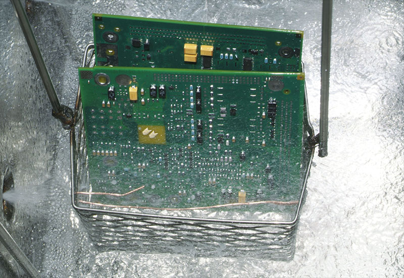 right: Circuit Board in Vapour  Degreaser- PCBs come out of the vapour degreaser clean, dry, spot-free and cool